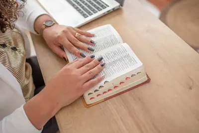 Manos sobre la Biblia abierta
